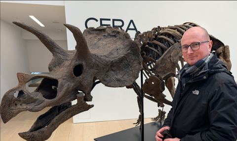 Thomas Eisenbarth neben einem Triceratops-Skelett im Museum